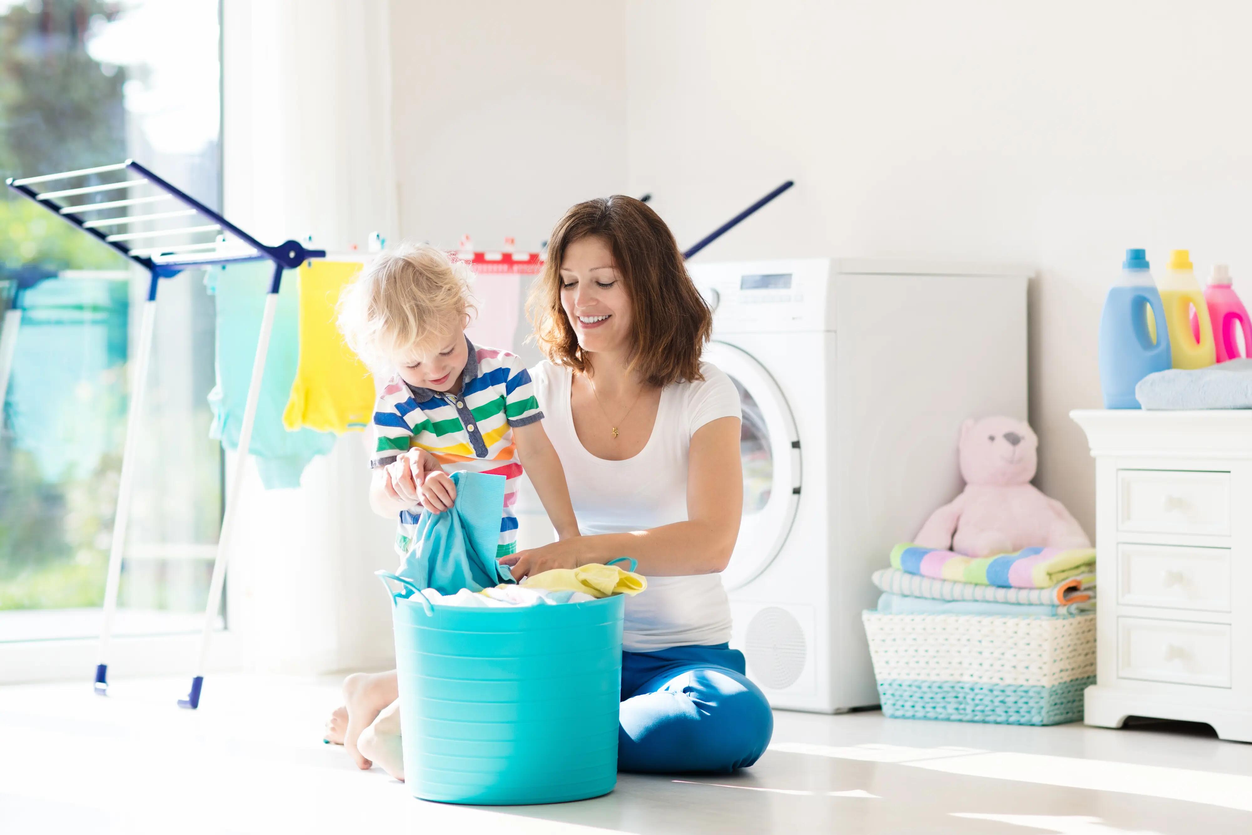 mom and toddler folding laundry